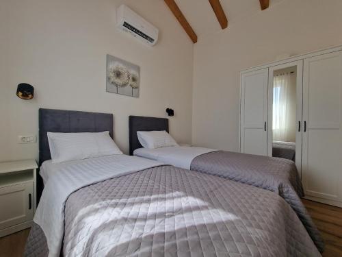 two beds sitting next to each other in a bedroom at Apartments Miamare in Primošten