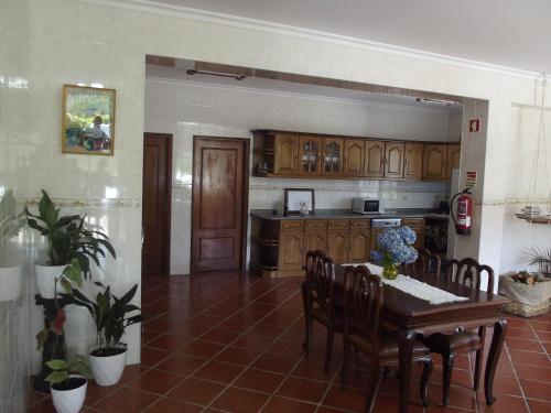 een keuken met een tafel en stoelen en een keuken met een aanrecht bij Quinta do Pina in Guarda