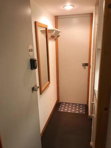 a hallway with a door and a mirror in a room at Studio chalereux au pied des pistes in La Plagne