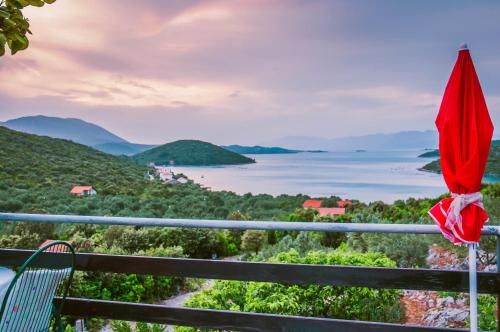 a red umbrella on a balcony looking out at the water at Bellavista Peljesac Peninsula in Dubrava