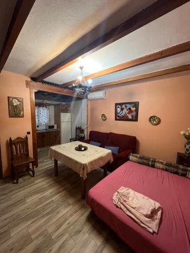 Sala de estar con cama roja y mesa en Apartamento Cerro De Las Salinas en Ronda