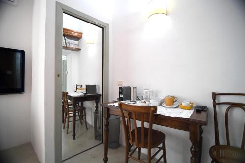 a dining room with a table with chairs and a mirror at Domo Peonia Bianca in Nuoro