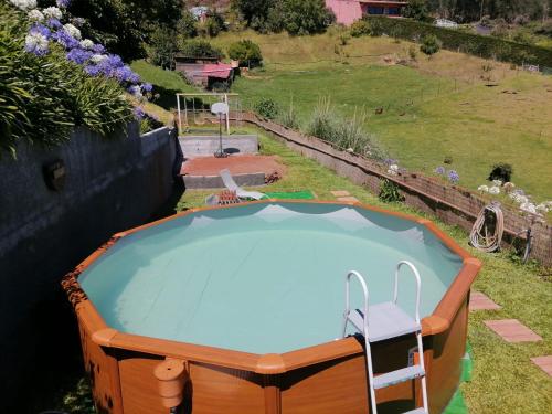 a small swimming pool with a chair in a yard at Cantinho Rural in Camacha