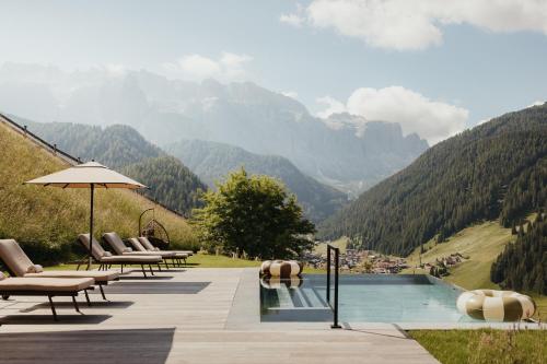 a swimming pool with a view of a mountain at Luxury Spa Chalet Lum d'Or in Selva di Val Gardena