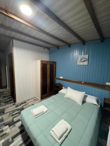 Una habitación azul con una cama con dos toallas. en Alojamiento cerro d la salina, en Ronda