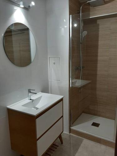 une salle de bain avec un lavabo et une douche avec un miroir dans l'établissement location vue mer du samedi au samedi, clim, parking, piscine, plage, à Collioure
