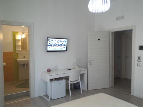 a room with a desk and a sign on a wall at B&B Costa Sicula in Avola