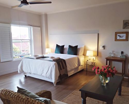 a bedroom with a large bed and a table at Apartment at Hermanus Waterfront in Hermanus