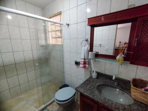 uma casa de banho com um WC, um lavatório e um espelho. em Casinha da Vovó em São Lourenço