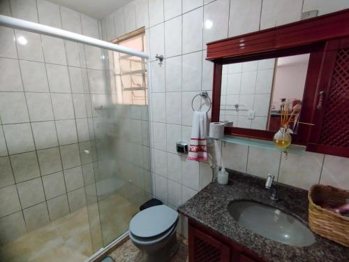 a bathroom with a toilet and a sink and a mirror at Casa com piscina próxima a pontos turísticos in São Lourenço