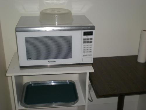 a microwave sitting on top of a table at Motel Vaudreuil in Vaudreuil-Dorion