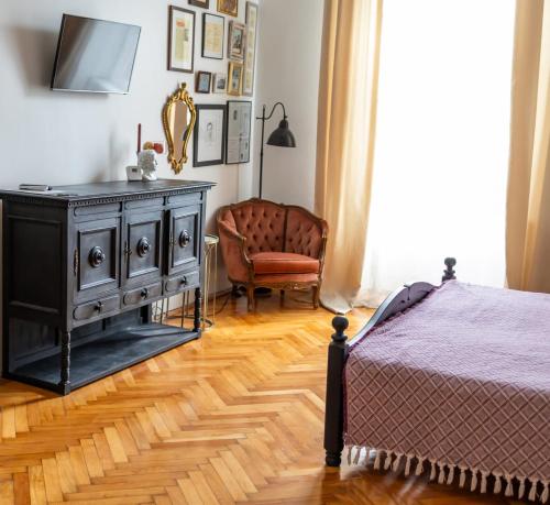 um quarto com uma cama, uma cómoda e uma cadeira em Maxim's place em Timisoara