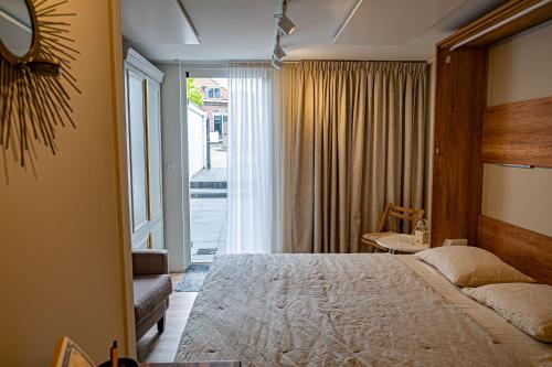 um quarto de hotel com uma cama e uma janela em B&B de Drukkerij Zandvoort - luxury private guesthouse em Zandvoort