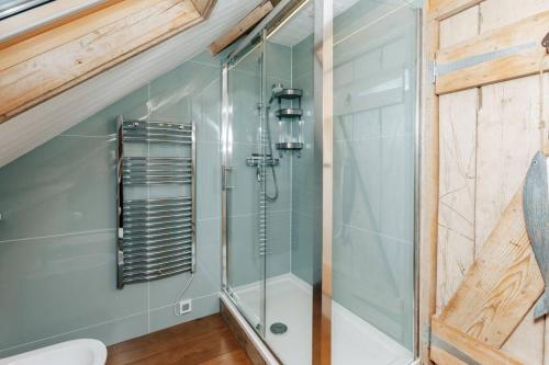 a bathroom with a shower with a glass door at Moonlight Barn in Oxford