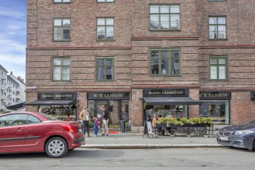 un coche rojo estacionado frente a un edificio de ladrillo en Apartment in the best part of Oslo, en Oslo