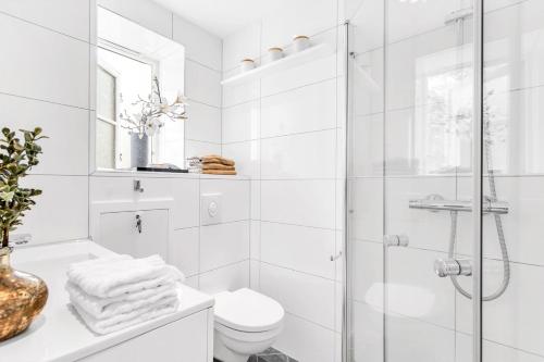 y baño blanco con ducha y aseo. en Apartment in the best part of Oslo, en Oslo