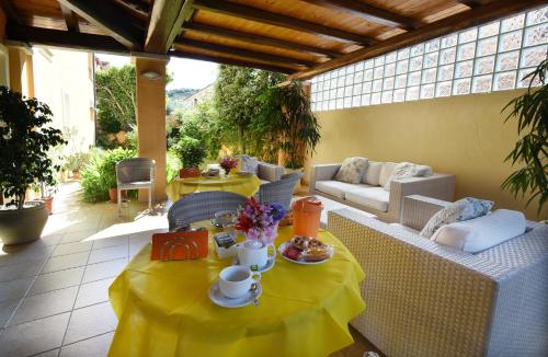 a table with a yellow table cloth on a patio at Hotel Il Girasole in Villasimius