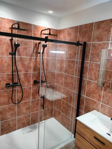 une douche avec une porte vitrée dans une salle de bain dans l'établissement Logement Cosy entre Vigne&Océan, à Castelnau-de-Médoc