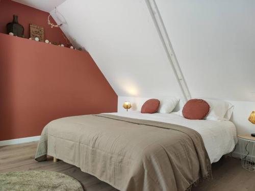 a bedroom with a large bed with red walls at Gîte de famille proche de la mer trédarzec in Trédarzec