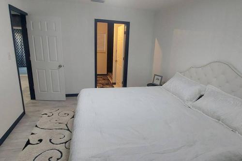 a bedroom with a large white bed and a hallway at Retreat Overlooking Lake Dora! in Tavares