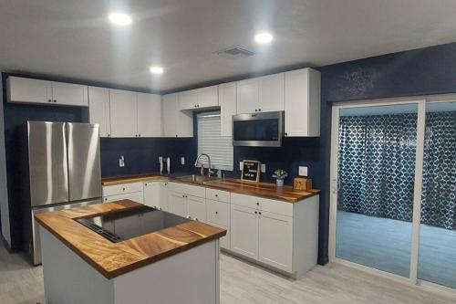 a kitchen with white cabinets and a stainless steel refrigerator at Retreat Overlooking Lake Dora! in Tavares