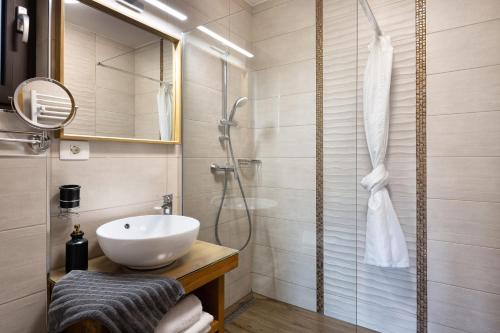 y baño con lavabo y ducha. en Hiša Vally Art en Bled