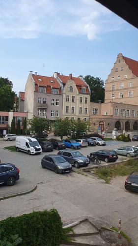 a parking lot with cars parked in front of buildings at Apartament Olsztyn Centrum in Olsztyn
