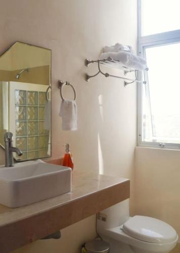 a bathroom with a sink and a toilet and a mirror at An amazing stay in Progreso, close to everything in Progreso