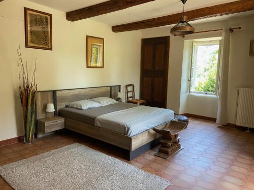 1 dormitorio con cama y ventana en La Frigoule, un gîte au cœur du parc des Cévennes, en Générargues