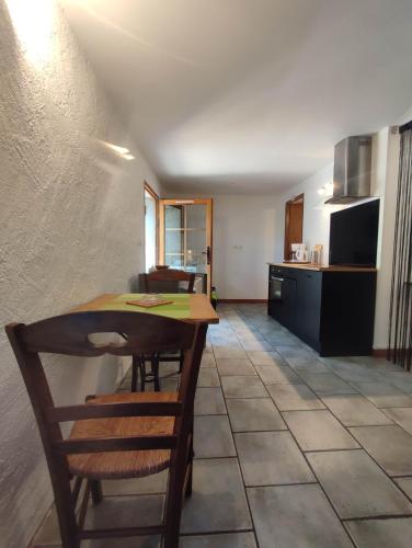 une cuisine avec une table et des chaises dans une pièce dans l'établissement La Soulane, à Cucugnan
