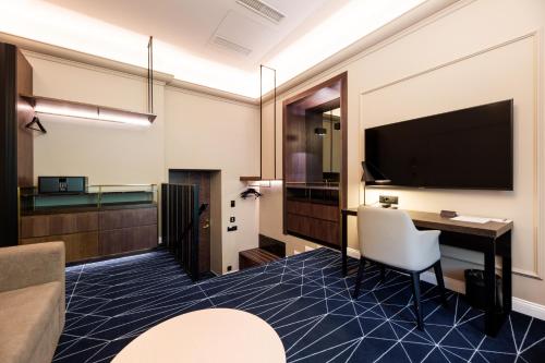a hotel room with a desk and a flat screen tv at Movenpick Hotel Tallinn in Tallinn