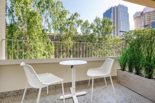 two chairs and a table on a balcony with a view at Movenpick Hotel Tallinn in Tallinn