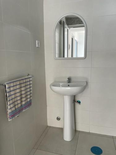 een witte badkamer met een wastafel en een spiegel bij Apartamento in Praia