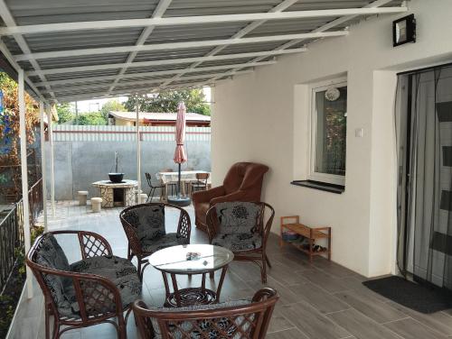 une terrasse couverte avec des chaises et une table. dans l'établissement Stella Apartman, à Hajdúszoboszló