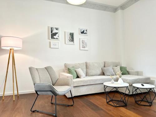 een woonkamer met een bank en 2 stoelen bij MyStay: Zentral I Design I Prime I Gäste WC in Heidelberg