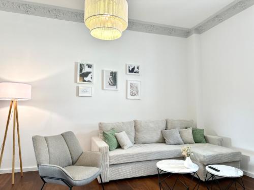 uma sala de estar com um sofá e duas cadeiras em MyStay: Zentral I Design I Prime I Gäste WC em Heidelberg