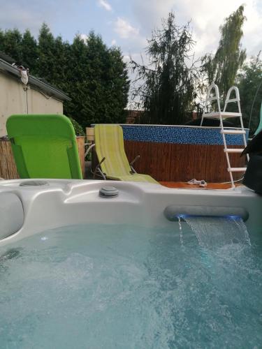a swimming pool with a chair and water in it at Chalupa u Manišov in Laskár