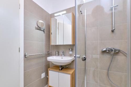 ein Badezimmer mit Waschbecken und Dusche in der Unterkunft Apartment Nora in Mali Lošinj