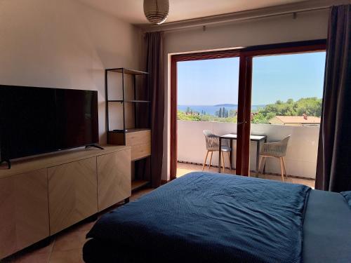 Un dormitorio con una cama, un televisor y una mesa. en Fažana INN, en Fažana