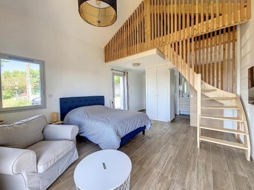 ein Wohnzimmer mit einem Bett und einer Treppe in der Unterkunft Gîte Le Panoramique in Bilieu
