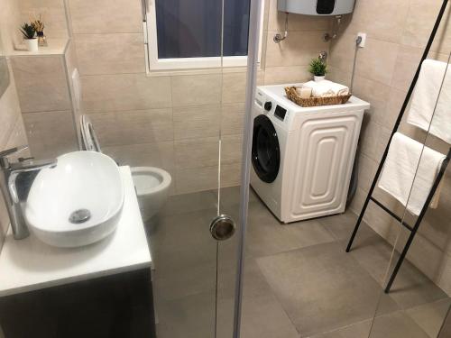 a bathroom with a washing machine and a sink at Holiday House Maze with jacuzzi in Novalja