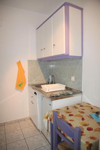 a kitchen with a table and a sink and a counter at Deep Blue Studios in Logaras