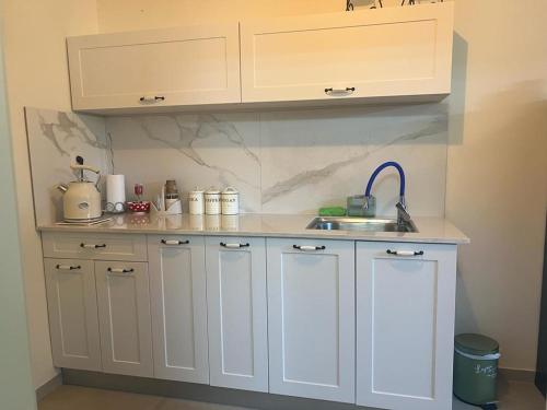 a kitchen with white cabinets and a sink at נקודות ריפוי in Tirat Karmel