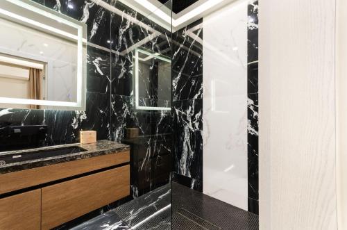 a black bathroom with a shower and a sink at Luxury apartment close to the city centre in Chişinău