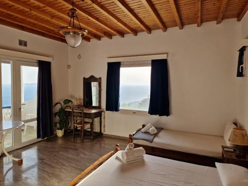 una camera con letto, scrivania e finestra di Fanari sea view studios a Fanari