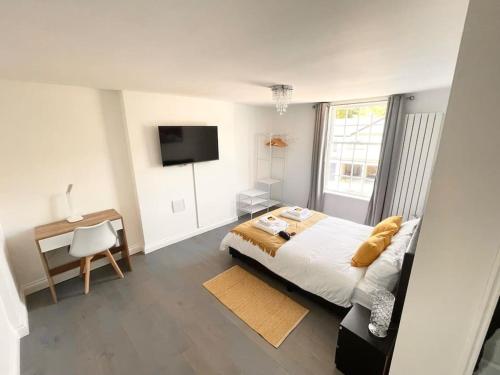 Dormitorio con cama, escritorio y TV en Entire Apartment hosted by Pius, en Redhill