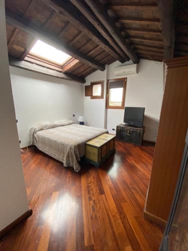 1 dormitorio con 1 cama y suelo de madera en San Marino Skyline - Suite Virgilio en San Marino