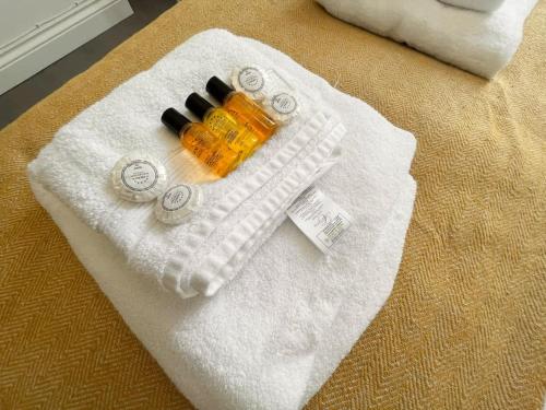 uma toalha branca com um frasco de perfume numa cama em Entire Apartment hosted by Pius em Redhill