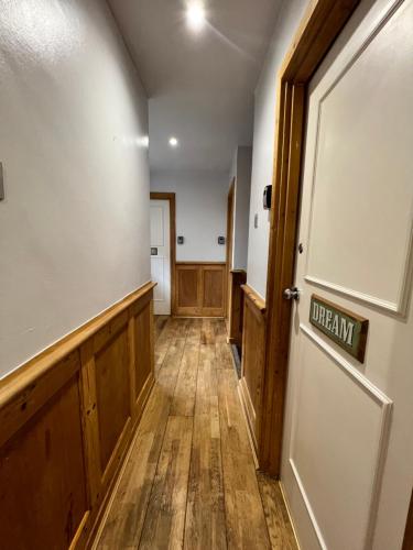 a hallway with wooden floors and a door at Beautiful Room for ONE Person - free Netflix, Amazon Prime & Disney plus in Bromley