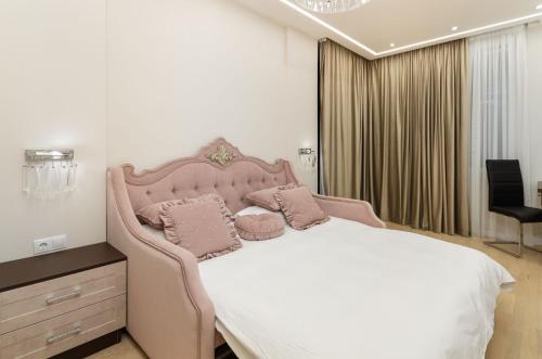 ein Schlafzimmer mit einem großen rosa Bett mit zwei Kissen in der Unterkunft Luxury apartment close to the city centre in Chişinău